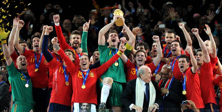 Spain's goalkeeper Iker Casillas (C) raises the trophy handed to him by FIFA President Sepp Blatter (4thR) and South Africa’s President Jacob Zuma (3rdR) as Spain's national football team players celebrate winning the 2010 World Cup football final Netherlands vs. Spain on July 11, 2010 at Soccer City stadium in Soweto, suburban Johannesburg. NO PUSH TO MOBILE / MOBILE USE SOLELY WITHIN EDITORIAL ARTICLE - TOPSHOTS AFP PHOTO / GABRIEL BOUYS